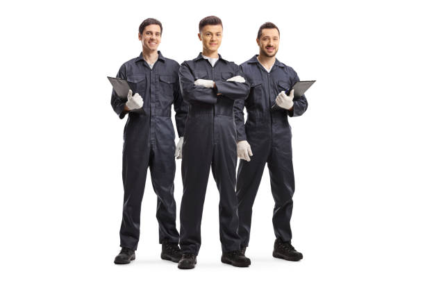 Full length portrait of three mechanic workers in uniforms isolated on white background